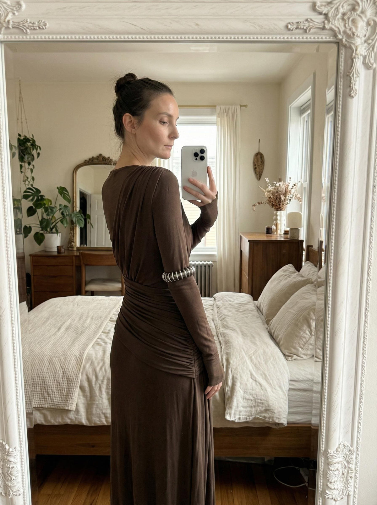 Brown high-neck maxi gown photographed from behind in a bedroom mirror, showing the back of the bodice and ruched waist.